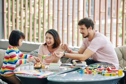 Parents giving puzzle to little daughter