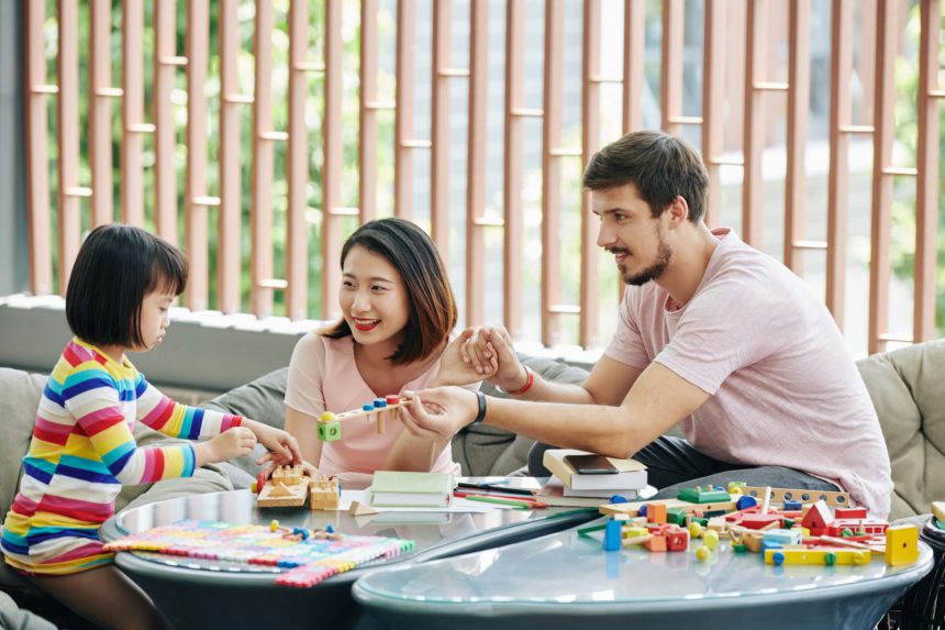Parents giving puzzle to little daughter