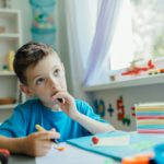 Thinking student doing his homework at home