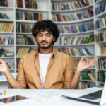 Young man practicing mindfulness meditation in a peaceful library setting