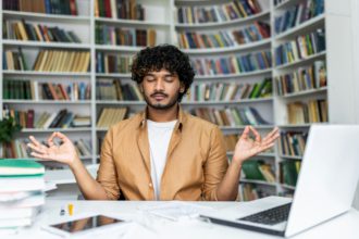 Young man practicing mindfulness meditation in a peaceful library setting