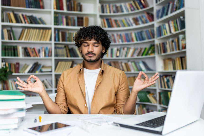 Young man practicing mindfulness meditation in a peaceful library setting